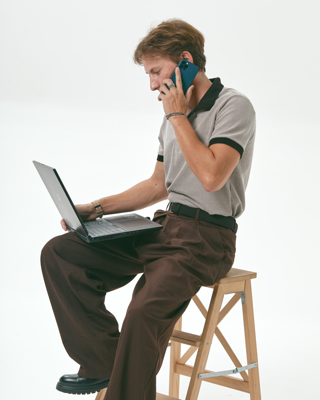 Michael Volgin on the phone while working on a laptop